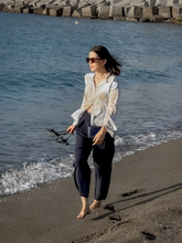 a lady wears a silk map printed shirt with a navy blue wide leg pants
